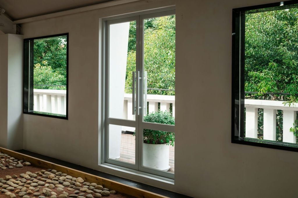 Un lit placé sous trois fenêtres dans une chambre
