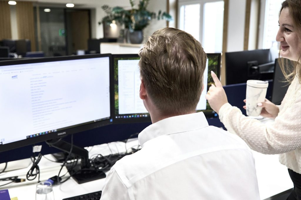 Deux collègues collaborent sur des ordinateurs de bureau