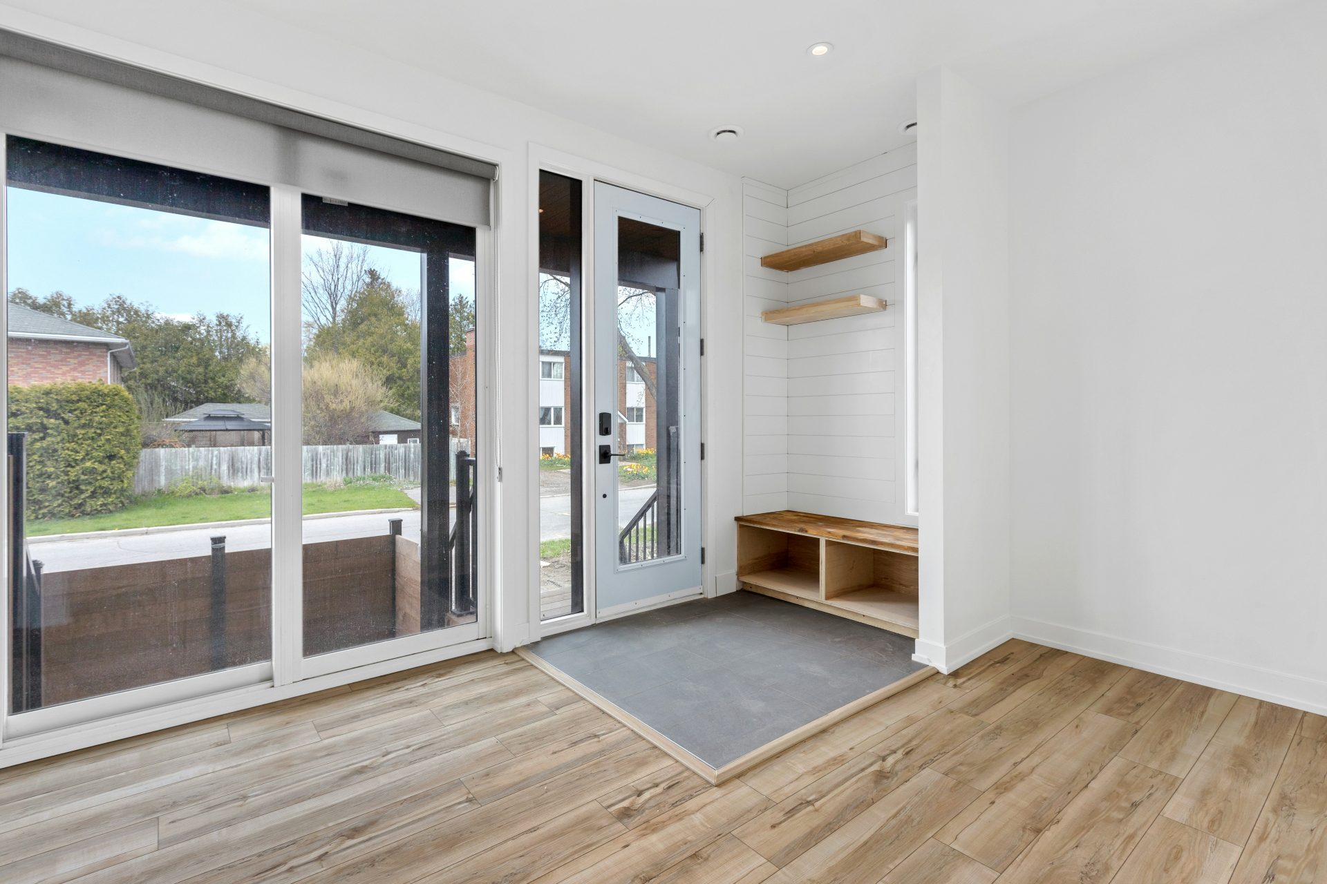 une pièce avec un parquet et une porte vitrée avec un tapis et un parquet avec un
