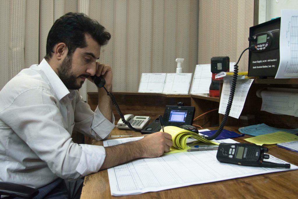 un homme assis à un bureau en train de parler au téléphone